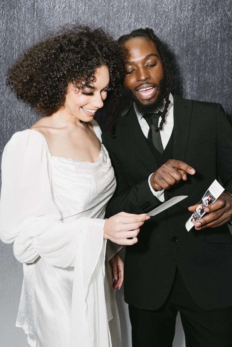 Guests laughing at their freshly printed photo booth strip