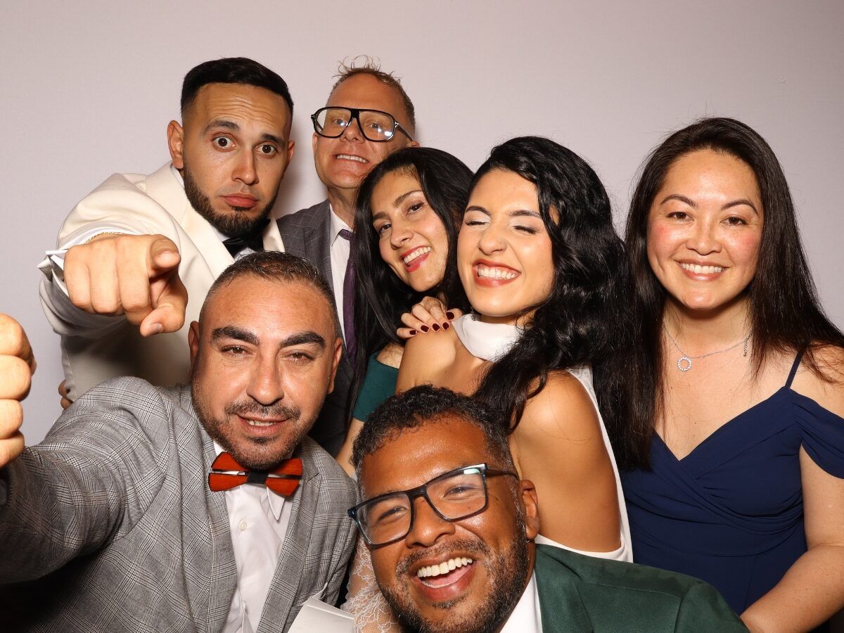 Friends posing with props in the photo booth